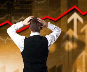 Young businessman thinking and analyzing financial graphs