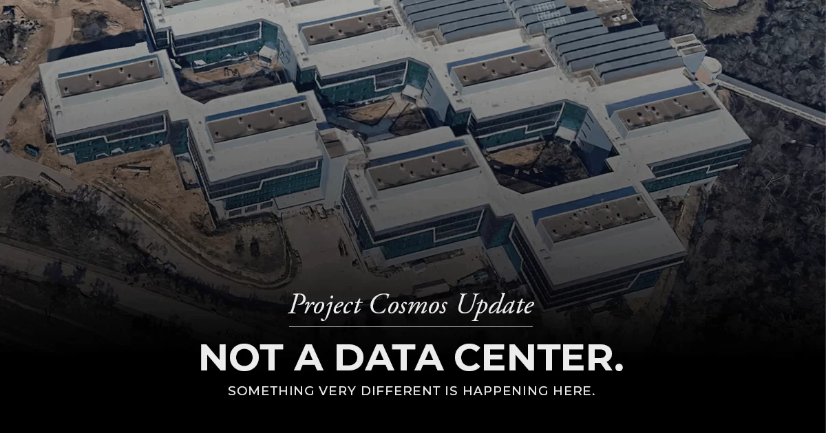 Aerial view of a multi-wing modern building complex with white roofs, acting as a hero banner for 'Project Cosmos Update' with the bold message 'NOT A DATA CENTER.'